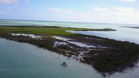 AERIAL: pulling away and tilting down over the ocean surrounding Nest Key, Stock Footage 100464426