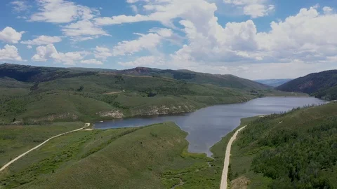 Aerial-Pulling back from beautiful high mountain lake-Gravel roads Stock-Footage 112363719