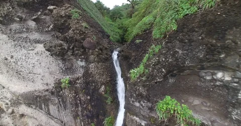 Aerial pulling back from the crest of Wavin Cyrique waterfall to reveal beach Vídeos de archivo 70341823