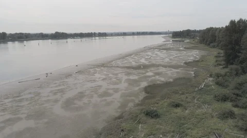 Aerial pulling back down the banks of the river Stock Footage 128930489