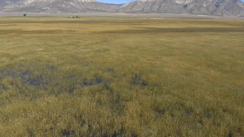 Aerial-Pulling back low over flooded marshland in rural mountain valley Vídeo Stock 112361007