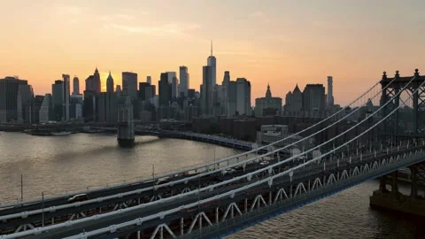 Aerial pulling back over cars driving Manhattan Bridge with sunset skyline NYC 스톡 동영상 218059018