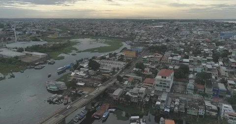 Aerial pulling back over poor waterside dwellings and marshes in downtown Manaus 스톡 동영상 101290874
