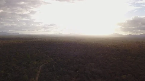 Aerial Pulling Back Over Remote African Dirt Road Into Golden Sun Stock-Footage 101976535