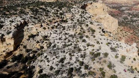 Aerial-Pulling back over off road vehicles driving rugged Devils Race Track Stock Footage 97239555