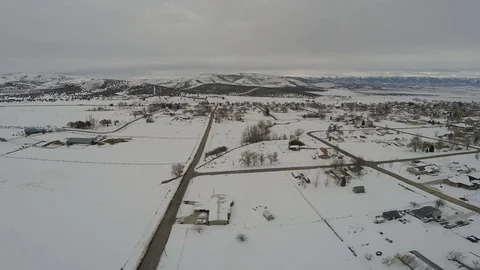Aerial Pulling back over snowy outskirts away from small rural mount Stock Footage 72366115