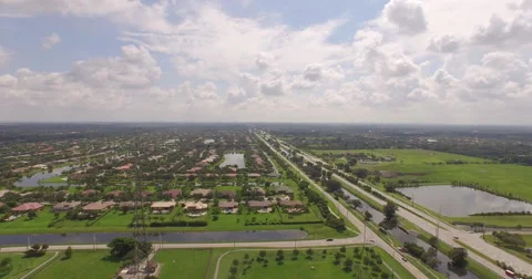 Aerial pulling back over Suburban Neighborhood with Wonderful Cloud Formation Stock Footage 55697423