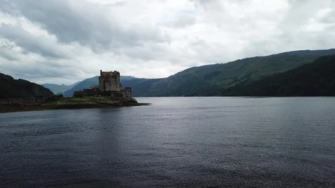 Aerial Pulling Back Over Water Away From Eilean Donan Scottish Castle On Island Video stock 125183458