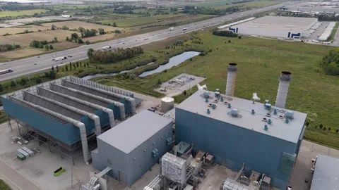 Aerial Pulling back from power plant with highway on the left Stock Footage 250489771
