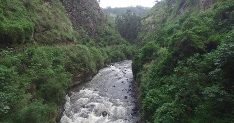 Aerial pulling over a river, through an arch and up and reveal a church Vídeos de archivo 72611025