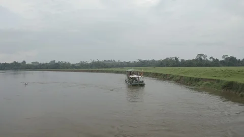Aerial pulls back and up from a ferry sailing on the Rio Orteguaza in Caqueta Stock-Footage 104732786