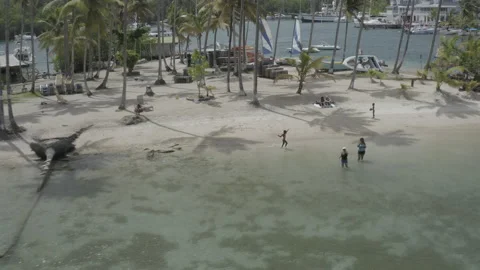 Aerial pulls back and up from handwritten "St. Lucia" in the sand of Marigot Bay Видео 209433405