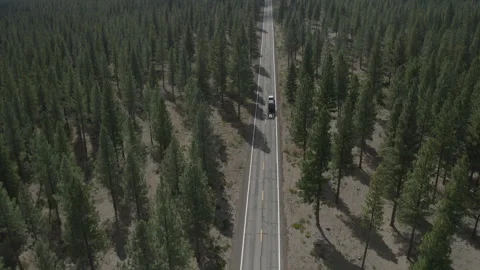Aerial pulls back and tilts up over highway to reveal Lassen Peak in distance Vídeos de archivo 324523890