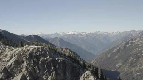 Aerial pulls back low over ridge from mountains in North Cascades, Washington Stock Footage 345176881