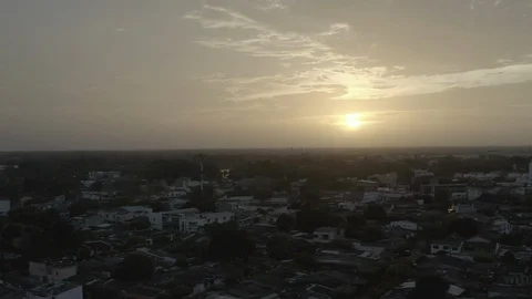 Aerial pulls back over dark city of Monteria, Colombia from a beautiful sunset Stock-Footage 107896617