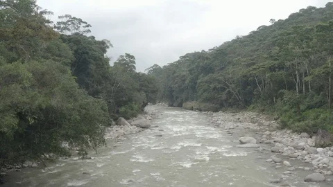 Aerial pulls back over a rushing river outside of Mocoa, Putumayo in Colombia Stock-Footage 104877142