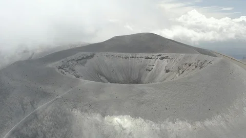 Aerial pulls back from the Puracé volcano crater as clouds moves cross frame Video stock 105029376