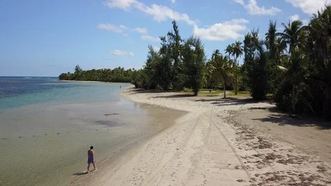 Aerial Pulls Back to Reveal Beautiful Woman Walking on Secluded Tropical Beach 스톡 동영상 101652665