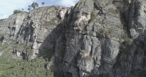 Aerial pulls back slowly from close to the rock wall of the Suesca rocks Видео 82402490