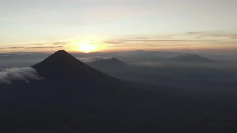 Aerial pulls back slowly looking at Volcan Agua in Guatemala during sunrise Video stock 167869929