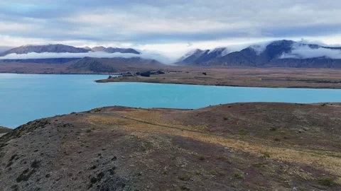 Aerial pulls out form pale blue mountain Lake Tekapo in New Zealand 库存影片 333029325