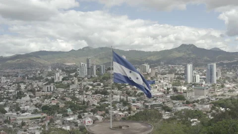 Aerial pulls out from Honduras flag to reveal cityscape of Tegucigalpa behind Stock-Footage 166483880