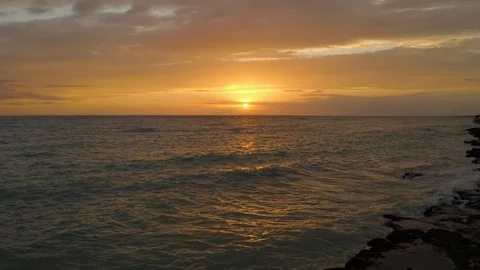 Aerial Push in across Caribean Ocean dring a deep orange Sunset Stock Footage