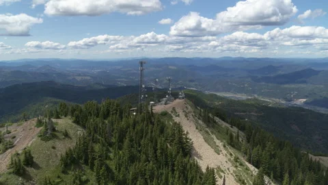 Aerial push forward on cell tower on mountain summit in northern Idaho Stock Footage 246523359