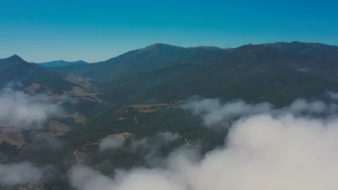 Aerial push forward skimming clouds towards jungle mountains Stock Footage 119571269