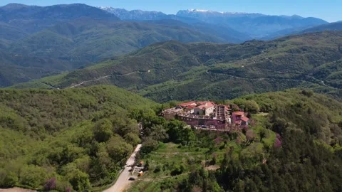 Aerial push out view of hidden mountain village above snowy mountain range Vidéo 337046551