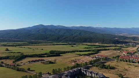 Aerial Push In Over Grassy Fields and Forested Hills in Razlog Bulgaria Vídeo Stock 343795494