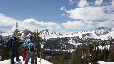 Aerial push over two backcountry skiers sharing a drink, mountain view Stock Footage 209988758