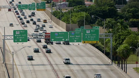 Aerial push-pull zoom on Miami Airport signs along highway 動画素材 136200650