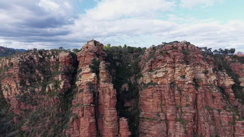 Aerial push-in toward dramatic red sandstone cliffs at Mirador de Garbi Video stock 326035053
