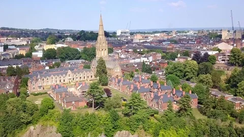 Aerial push toward St Leonards church spire in the Exeter, England, cityscape Vidéo 93422204