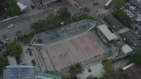 Aerial pushes in and tilts down over city soccer game in El Salvador Stock-Footage 168331453