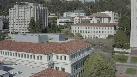 Aerial pushes over library rooftop towards another building on the Cal campus Vídeos de archivo 153494929
