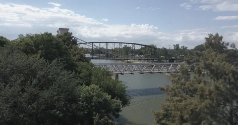 Aerial pushes through trees over the Waco Suspension Bridge to others Vídeos de archivo 94667676