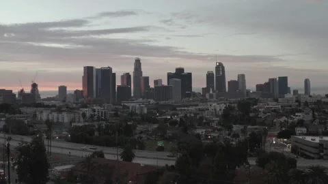 Aerial pushes towards 101 freeway with downtown LA skyline in back at dawn 스톡 동영상 150701145