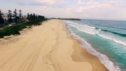 Aerial of quiet sandy beach with waves near a city Video stock 83534617