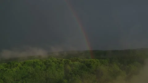Aerial of rainbow and low clouds above canopy of trees in Appalachian mountains Vidéo 203915472