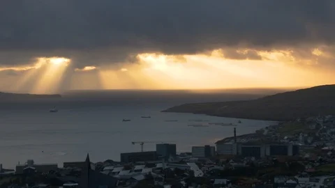 Aerial ray of sun light behind moving clouds city near sea down the mountains Stock Footage 92642785