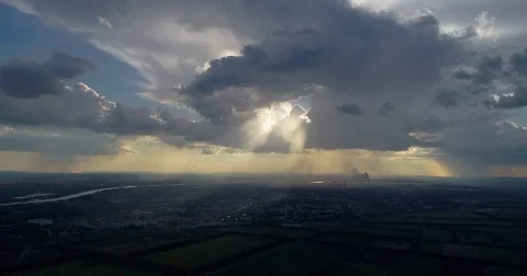 Aerial: The rays of the sun fall on the city through the clouds. It's raining. Stock Footage 78588370