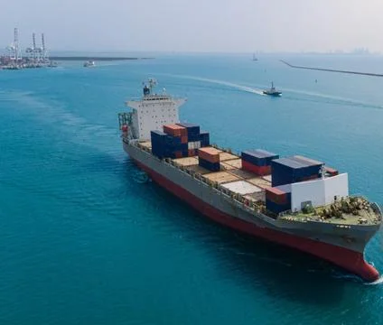 Aerial Rear View of Loaded Container Ship Escorted Out to Sea Stock Photos