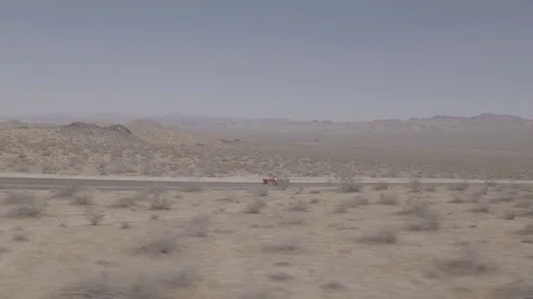 Aerial of Red Mustang in Empty Desert Road Vídeo Stock 79384997