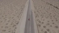 Aerial Of Red Mustang In Long Empty Desert Road Stock Footage