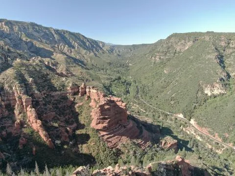 Aerial of red sandstone cliffs in pine tree forest in Sedona, Arizona Stock Photos