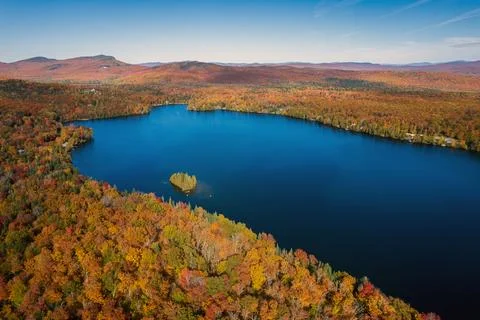 Aerial of remote lake in the mountains exploding with Autumn Colors Stock Photos