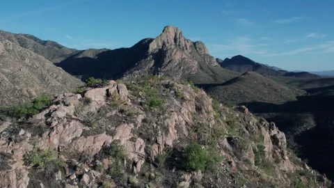 Aerial reveal of dramatic mountain peaks with a man at the summit Stock Footage 275056045