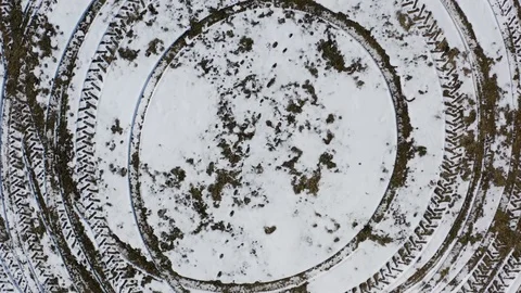 Aerial reveal of tracks in a circle pattern left in the snow by a tractor 스톡 동영상 112106085